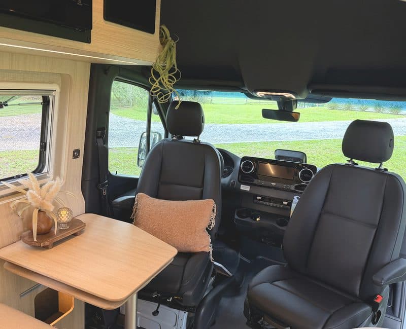 The dinette table and cab seats, looking out through the windshield