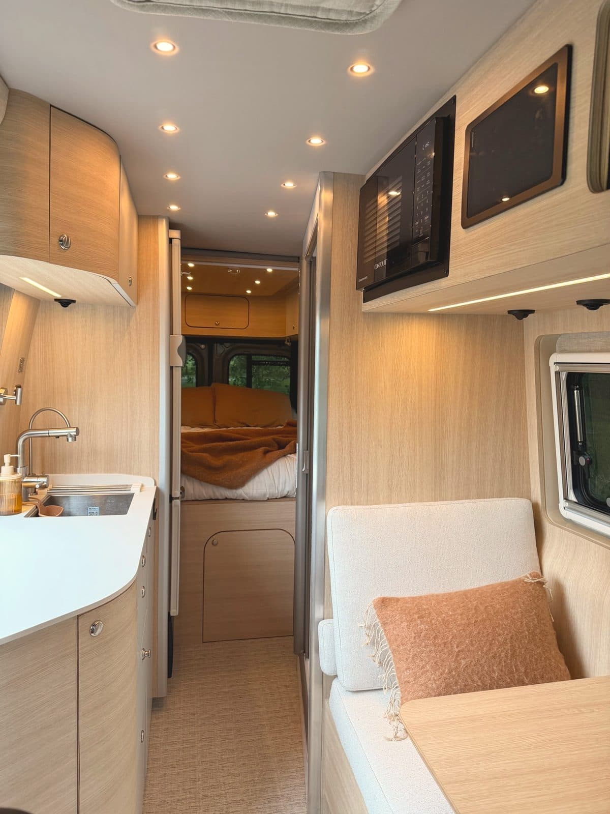 Inside Nellie, our Noovo Next camper van, looking from the galley toward the bed
