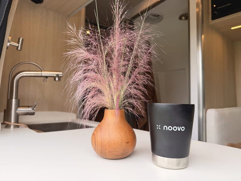 A vase of pink muhly and a Noovo tumbler on the galley counter
