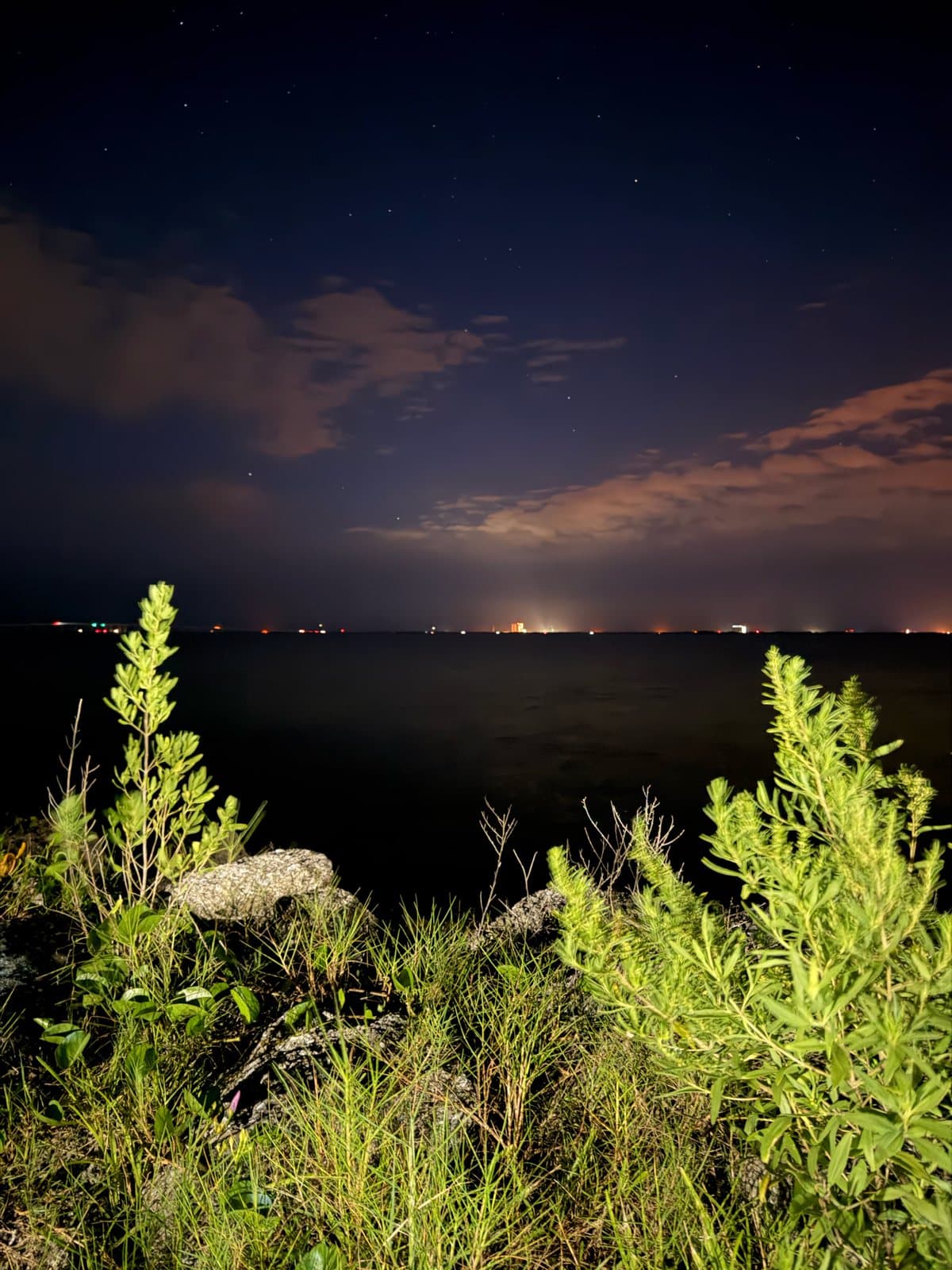 Stars over the Indian River with Space Coast lights across the water at night