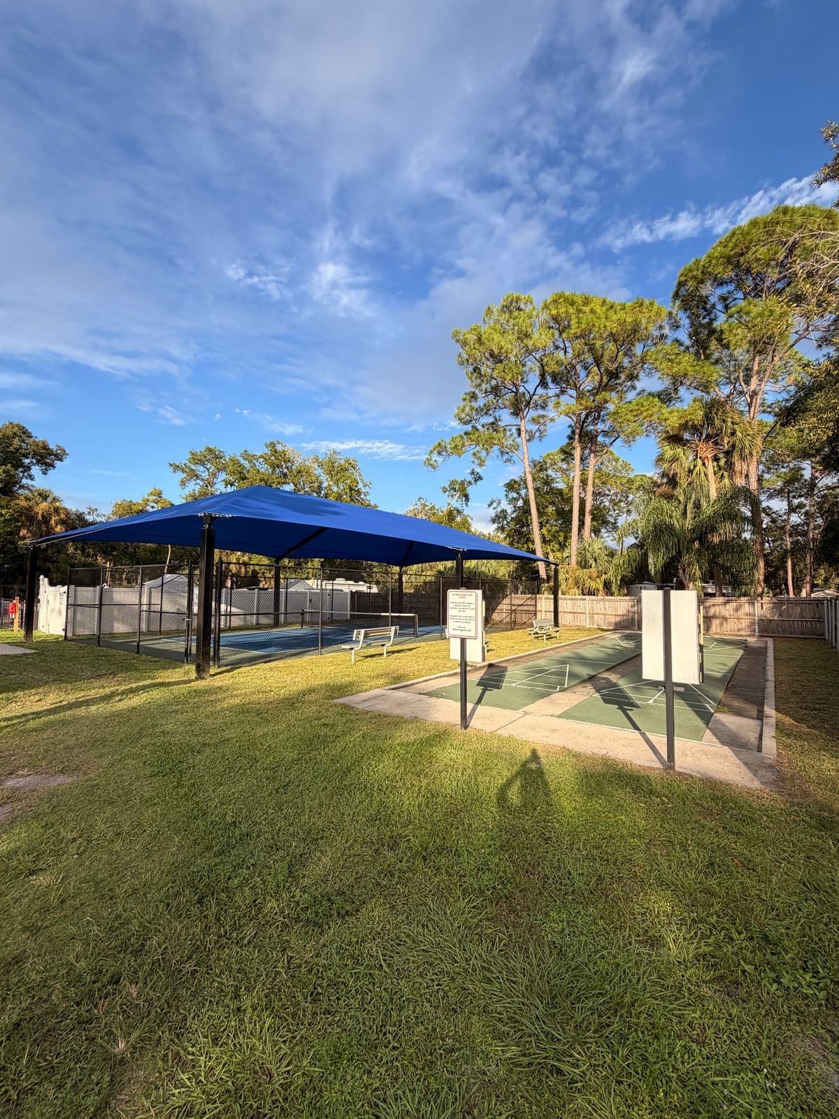 A shaded pickleball court and shuffleboard courts at Manatee Hammock Campground in Titusville
